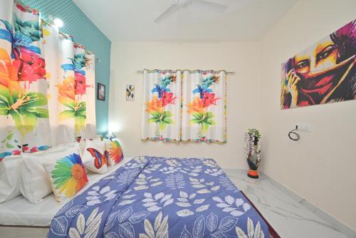 a bedroom with a bed with a blue comforter at ll EMPYREAN STAY ll LEONCINO VILLA II 4BHK ll AC ll LARGEST POOL ll in Lonavala