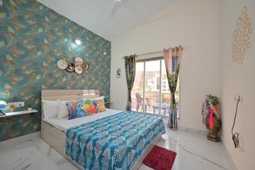 a bedroom with a bed with a blue patterned wall at ll EMPYREAN STAY ll LEONCINO VILLA II 4BHK ll AC ll LARGEST POOL ll in Lonavala