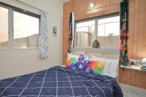 a bedroom with a bed with blue comforter and pillows at ll EMPYREAN STAY ll LEONCINO VILLA II 4BHK ll AC ll LARGEST POOL ll in Lonavala