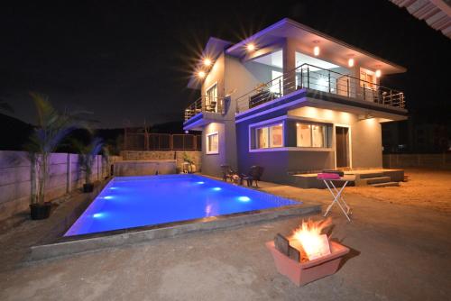 a house with a swimming pool at night at ll EMPYREAN STAY ll LEONCINO VILLA II 4BHK ll AC ll LARGEST POOL ll in Lonavala