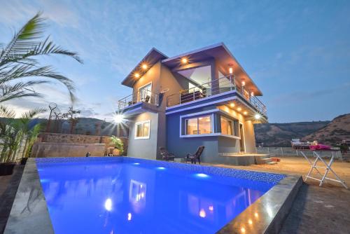 a house with a swimming pool in front of a house at ll EMPYREAN STAY ll LEONCINO VILLA II 4BHK ll AC ll LARGEST POOL ll in Lonavala