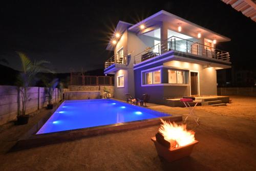 a house with a swimming pool at night at ll EMPYREAN STAY ll LEONCINO VILLA II 4BHK ll AC ll LARGEST POOL ll in Lonavala