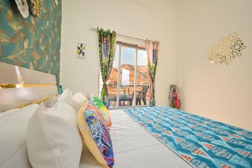 a bedroom with a bed and a window with a chair at ll EMPYREAN STAY ll LEONCINO VILLA II 4BHK ll AC ll LARGEST POOL ll in Lonavala