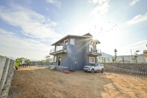 a house with a car parked in front of it at ll EMPYREAN STAY ll LEONCINO VILLA II 4BHK ll AC ll LARGEST POOL ll in Lonavala