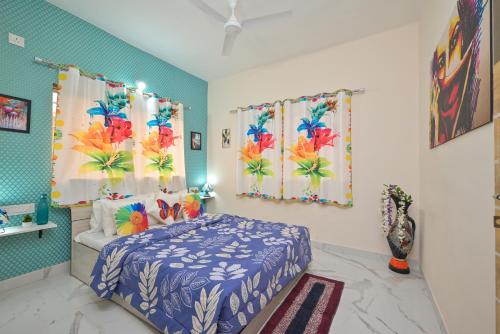 a bedroom with a blue and white bed and curtains at ll EMPYREAN STAY ll LEONCINO VILLA II 4BHK ll AC ll LARGEST POOL ll in Lonavala