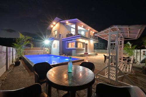a villa with a swimming pool at night at ll EMPYREAN STAY ll LEONCINO VILLA II 4BHK ll AC ll LARGEST POOL ll in Lonavala