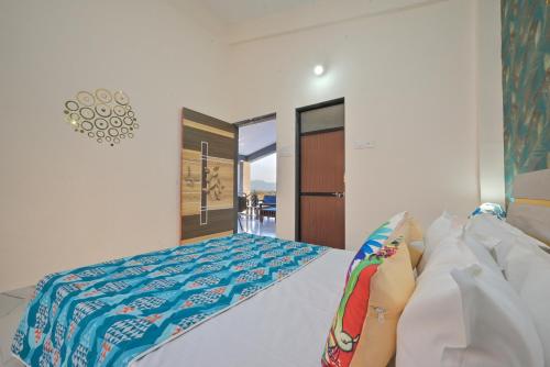 a bedroom with a bed with a blue comforter at ll EMPYREAN STAY ll LEONCINO VILLA II 4BHK ll AC ll LARGEST POOL ll in Lonavala