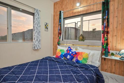 a bedroom with a blue bed with pillows and a window at ll EMPYREAN STAY ll LEONCINO VILLA II 4BHK ll AC ll LARGEST POOL ll in Lonavala