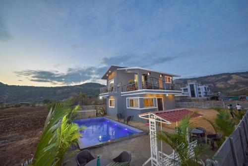 a house with a swimming pool in front of it at ll EMPYREAN STAY ll LEONCINO VILLA II 4BHK ll AC ll LARGEST POOL ll in Lonavala