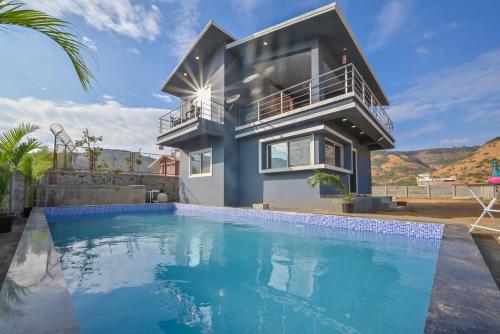 a house with a swimming pool in front of a house at ll EMPYREAN STAY ll LEONCINO VILLA II 4BHK ll AC ll LARGEST POOL ll in Lonavala