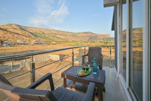 a table with a plate of food on top of a balcony at ll EMPYREAN STAY ll LEONCINO VILLA II 4BHK ll AC ll LARGEST POOL ll in Lonavala