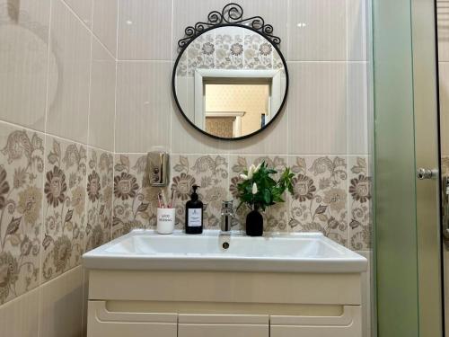 a bathroom with a sink and a mirror at Уютная квартира рядом с Батырмол in Pavlodar