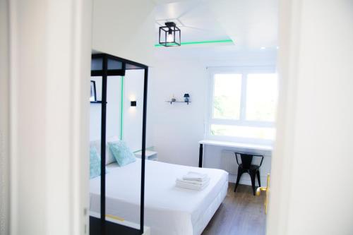 a white bedroom with a bed and a desk at Le Cocoon des Lierres - Séjour Zen près du Parc Astérix & CDG in Survilliers
