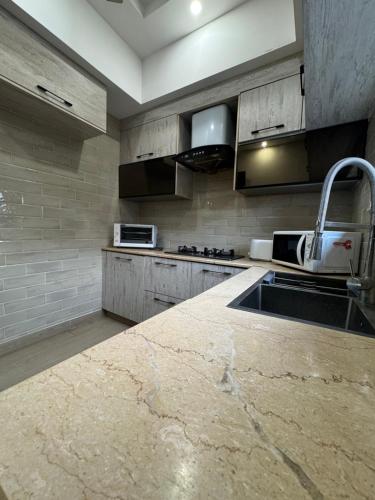 a kitchen with a sink and a counter top at 3 Bedroom Family Guesthouse - DHA Premium Modern Stay in Lahore