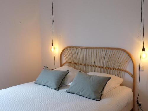a bed with two pillows on it in a room at Le GLAZ * Grande plage & commerces à pied * Jardin in Carnac