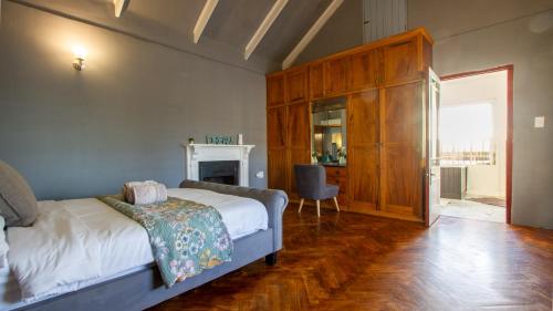 Un dormitorio con una cama y una silla en una habitación. en Berg River Living, en Velddrif