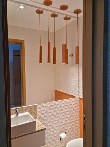 a bathroom with a sink and a mirror at Edifício Panoramique 180 Graus, Cobertura in Guarujá