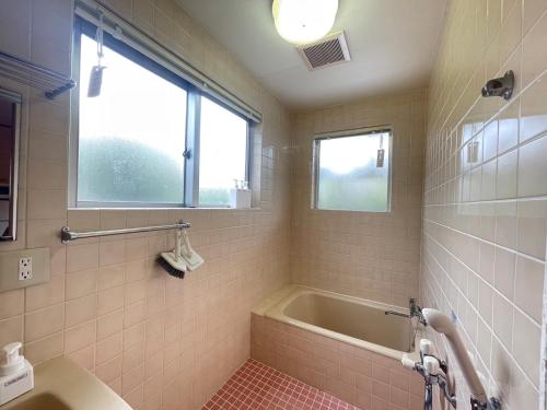 a bathroom with a bath tub and a window at CASA de RandN Nakama 1F in Onna