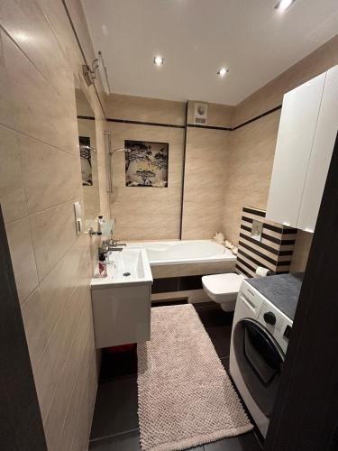 a bathroom with a sink and a tub and a toilet at Garden Spot and Parking in Krakow