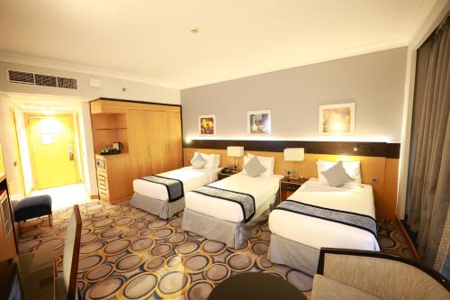 a hotel room with two beds and a table at فندق برستيج اجياد in Ajyad