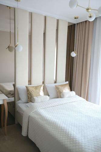 a bedroom with a large bed with white sheets and pillows at Apartment LUXOR - Airport Katowice-Pyrzowice in Bobrowniki