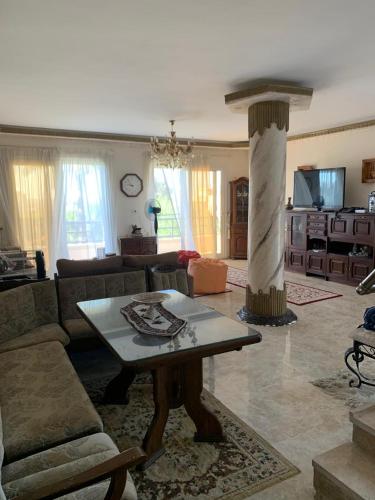 a living room with a couch and a table at Lovely Villa 5- bedroom with Overflow Pool with Nice Garden at Green Oasis Resort in Alexandria