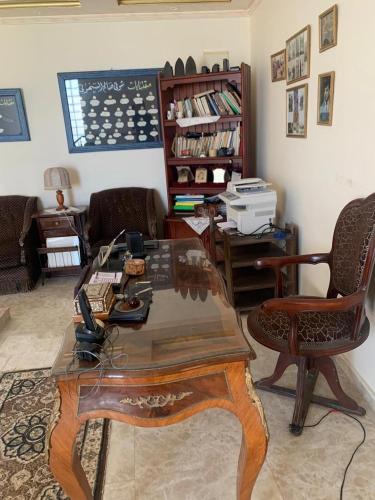 a living room with a coffee table and a desk at Lovely Villa 5- bedroom with Overflow Pool with Nice Garden at Green Oasis Resort in Alexandria