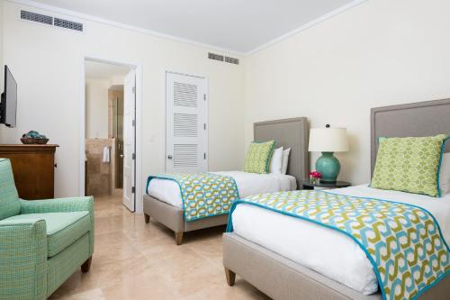 a bedroom with two beds and a couch and a chair at West Bay Club in Grace Bay