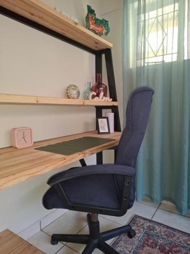 a desk and a chair in a room at Just Dandee in Naboomspruit