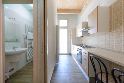 a kitchen with a sink and a counter with chairs at Hotel Sans Souci in Rimini