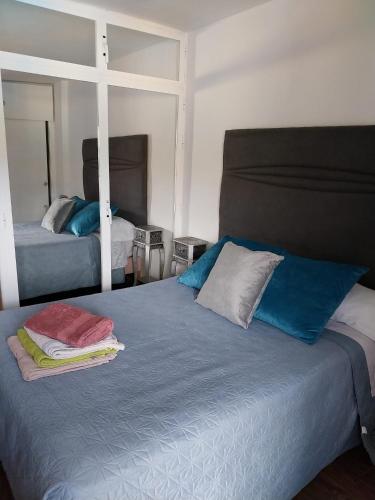 a bedroom with two beds with blue and white pillows at Jupiter Estudio in Benalmádena