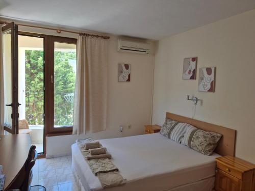 a bedroom with a bed and a large window at Villa Maxim in Varna City