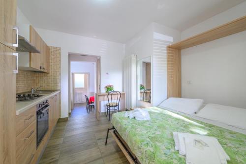 a small bedroom with a bed and a kitchen at Hotel Sans Souci in Rimini