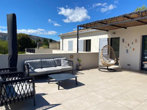 a patio with a couch and a chair at Vue Ventourist - vakantieloft in Malaucène