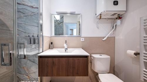 a bathroom with a toilet and a sink and a shower at Le Reflet - Vue Rivière et Caractère in Dijon
