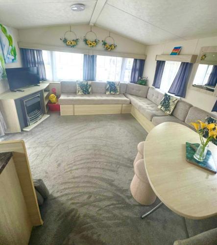 a living room with a couch and a table at Lyons Robin Hood , Rhyl in Rhyl