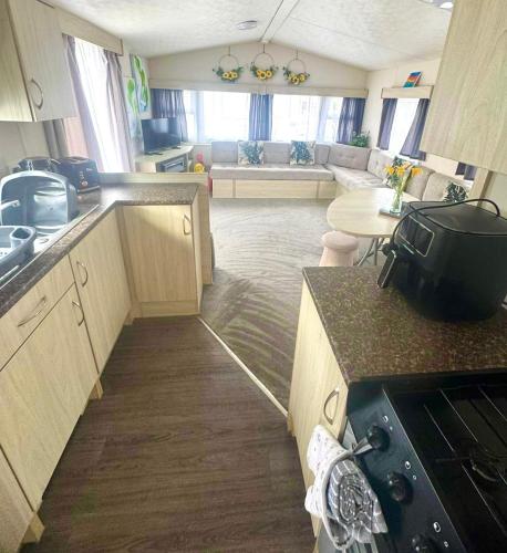 a kitchen and living room with a couch and a table at Lyons Robin Hood , Rhyl in Rhyl