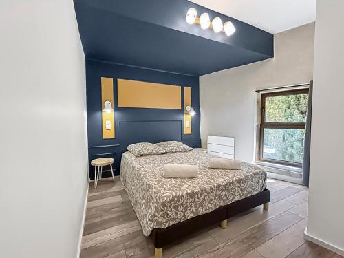 a bedroom with a bed and a blue wall at Élégant T3 à deux pas du centre ancien in Arles