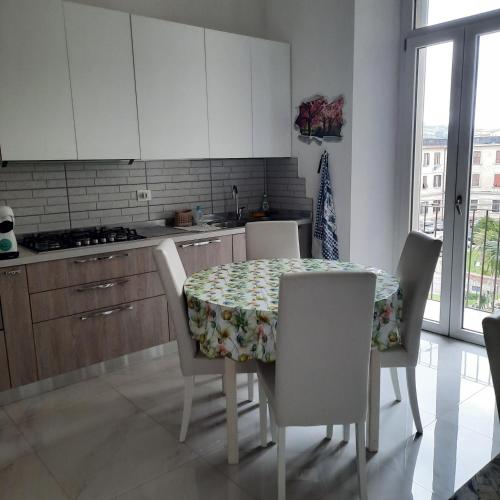 a kitchen with a table and chairs and a kitchen with white cabinets at Wellness at home in Ancona