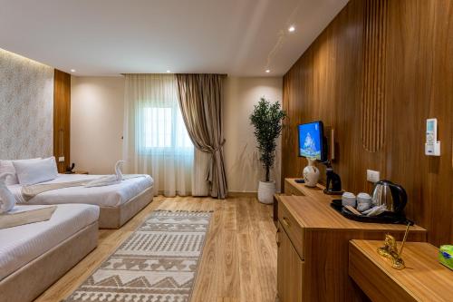 a hotel room with a couch and a bed and a tv at Pyramids sunrise inn in Cairo
