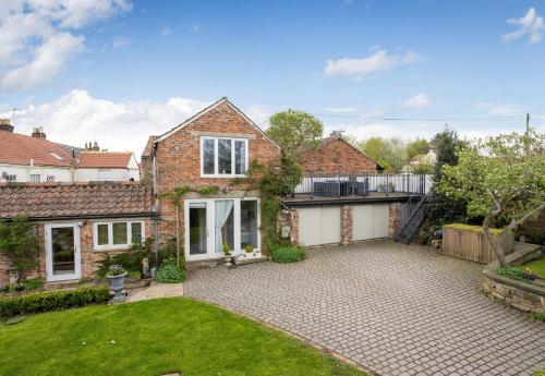 a brick house with a courtyard and a yard at Tanyard Barn - North Yorkshire in York