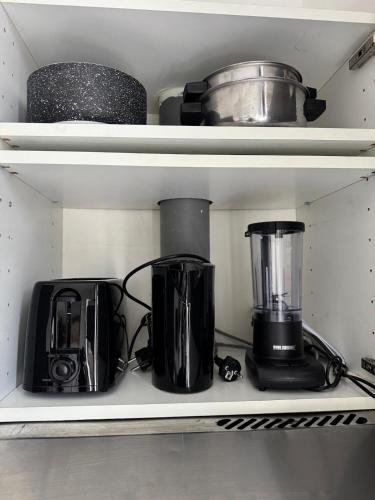 a kitchen shelf with various appliances on it at Charmant studio à 5 min de la Gare du Midi, 1-2 pe in Mellet