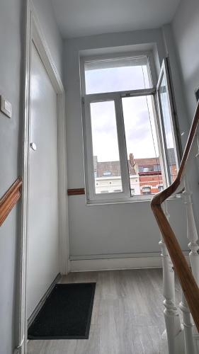 an empty room with a window and a staircase at Charmant studio à 5 min de la Gare du Midi, 1-2 pe in Mellet