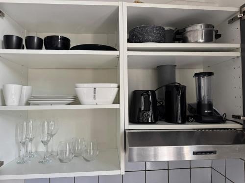 a kitchen with wine glasses and utensils at Charmant studio à 5 min de la Gare du Midi, 1-2 pe in Mellet