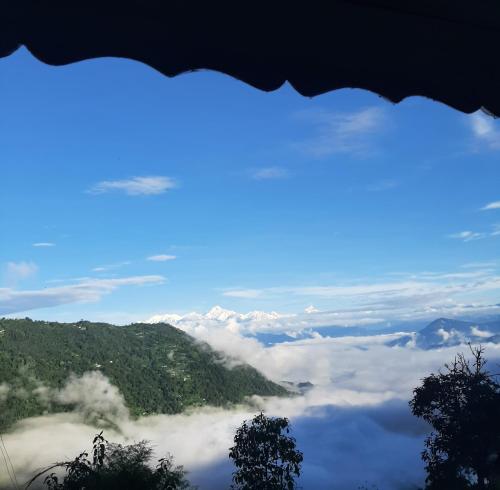 a view of a valley of clouds and mountains at KOLAKHAM SILVERPINE RETREAT HOMESTAY Pure Veg KOLAKHAM,LAVA in Lava