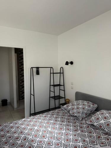 Saint-Orens-de-GamevilleにあるAppartement climatisé Saint Orens N8の白い壁のベッドルーム1室(ベッド1台付)