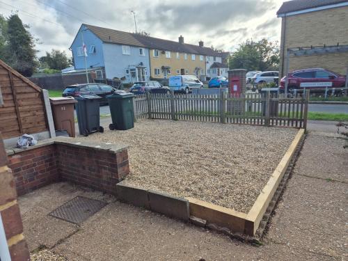a garden with a fence and two trash cans at Spacious 3BR Home with Large Garden - Ashford, Kent in Kennington
