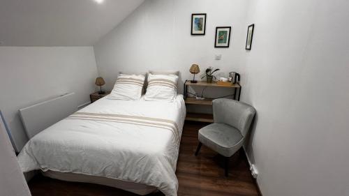 a small bedroom with a bed and a chair at Beaulieu La Source in Saumur