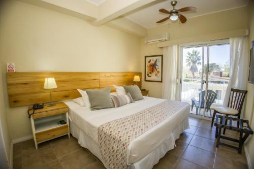 a bedroom with a large white bed and a window at Joan Miró Hotel in Punta del Este