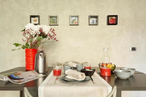 a table with a vase of flowers on top of it at San Babila Suite in Milan